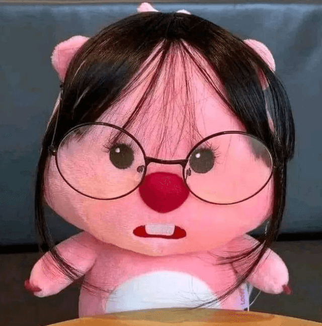 plushie of the Pororo character Loopy with large round glasses and straight hair with bangs